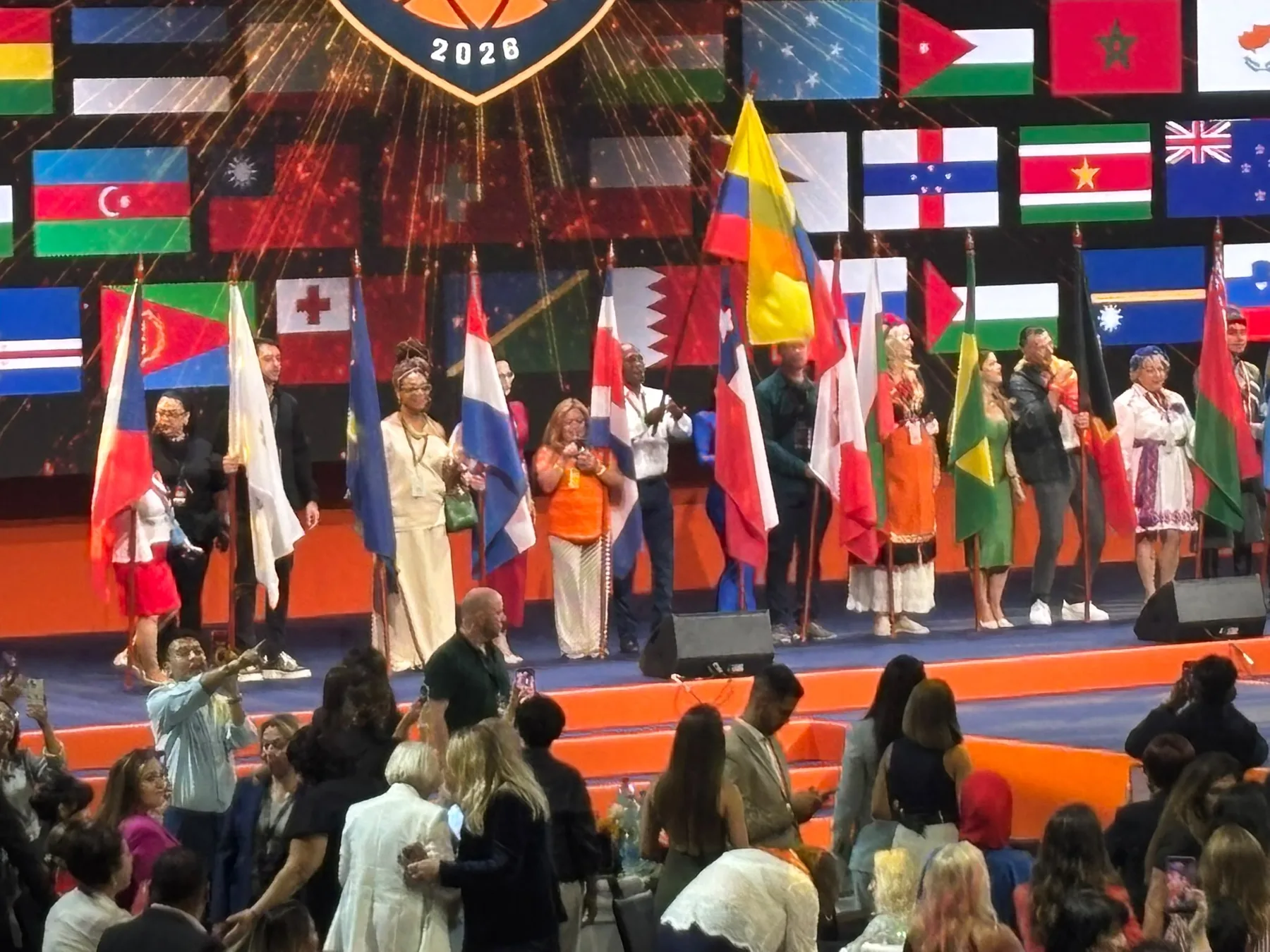 Participantes con banderas de distintos países sobre el escenario
