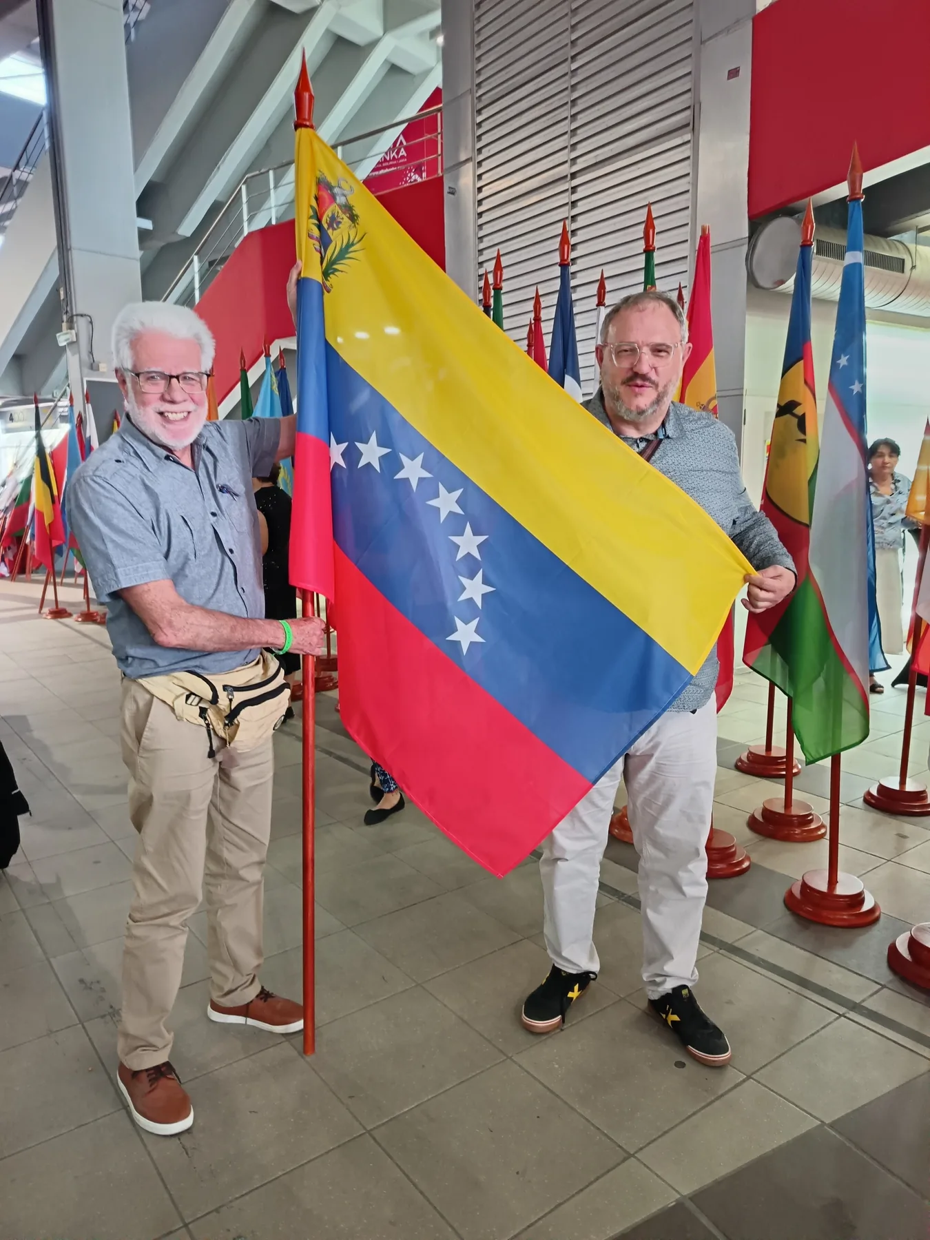 Andrés y Eduardo posando con la bandera de Venezuela durante The Global Convention 2026