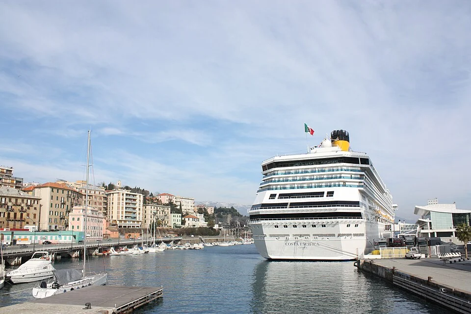 Costa Pacifica atracado en el puerto de Savona con la ciudad al fondo
